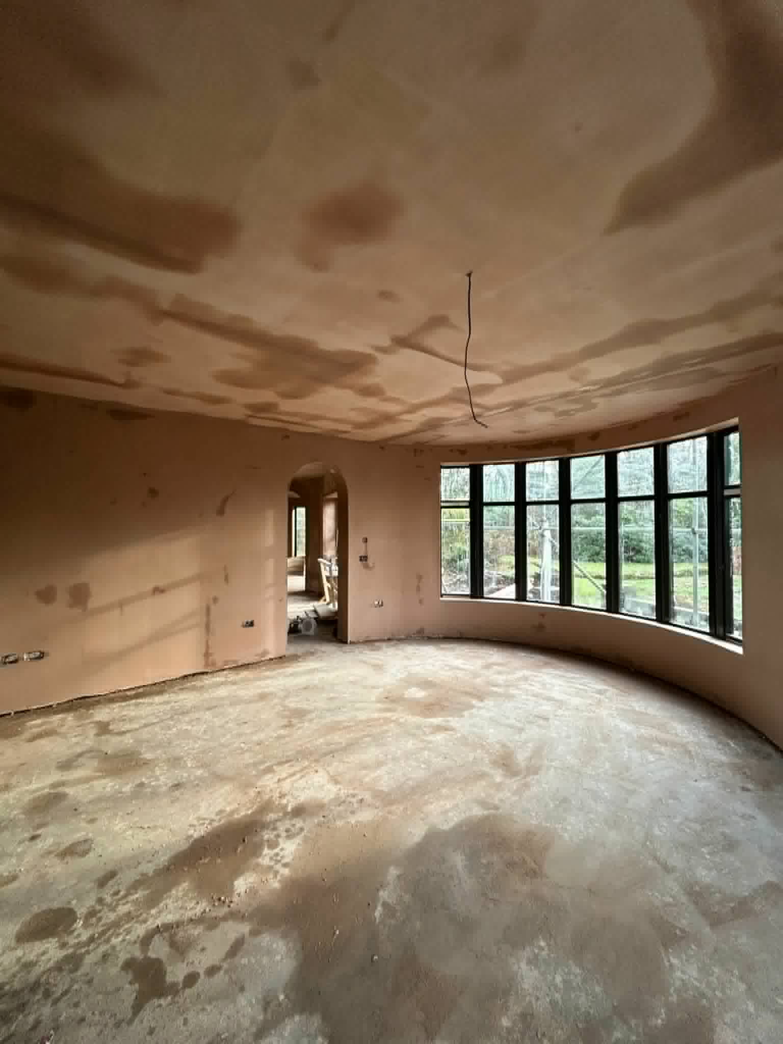 Curved bay room with freshly plastered ceiling and walls